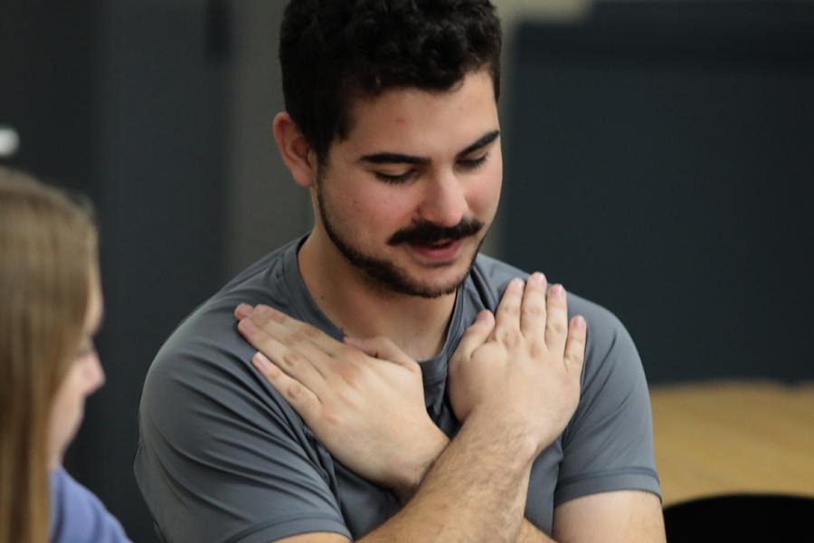 A student makes the sign for love in sign language.