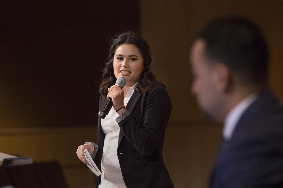 A young woman speaks into a microphone.