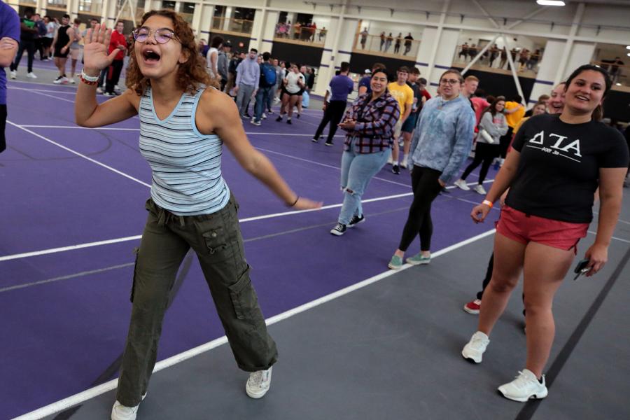 A student cups her mouth as she yells during a relay race in the fieldhouse.