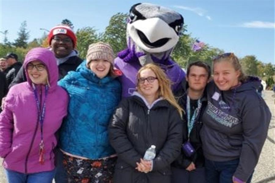 LIFE students pose with Willie the Warhawk at a football game.