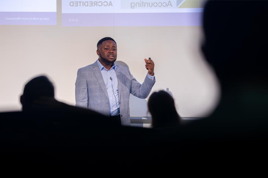 Patrice Achu defends his dissertation in front of a crowd.